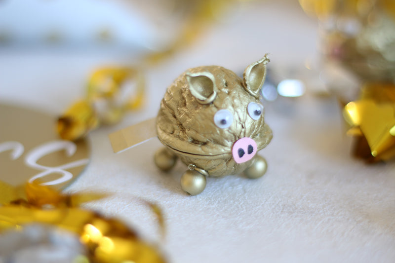 goldene Schweinchen als Tischdeko aus Walnüssen