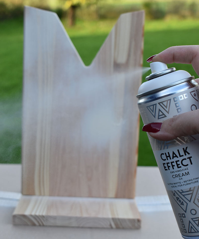 Holz wird mit der Cosmos Lac Farbsprühdose Chalk Effect Cream angesprüht