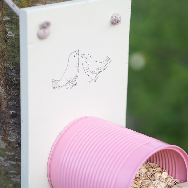 Selbstgebautes pinkes Vogelhaus mit Illustration von Vögeln