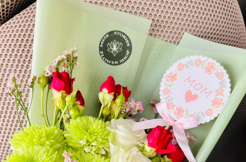 Blumen mit einem Aufsteller mit der Aufschrift Mom